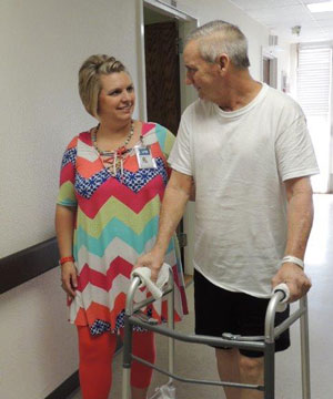 Female nurse assisting patient with walker